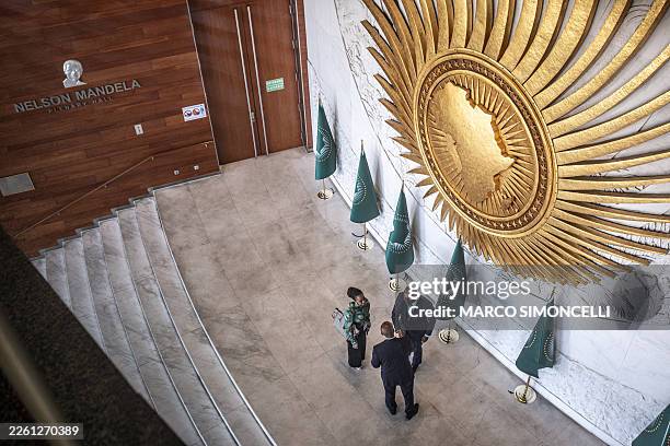 Delegates speak outside the entrance to the Nelson Mandela Hall during the 39th Ordinary Session of the Assembly of the African Union at the AU...