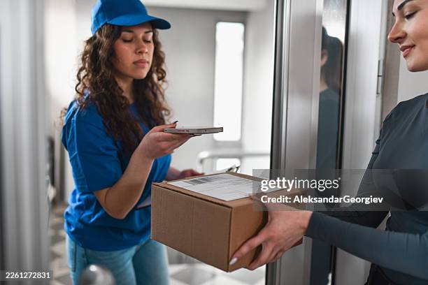 delivery person scanning package while recipient accepts box at home entrance - entrega sem contacto imagens e fotografias de stock