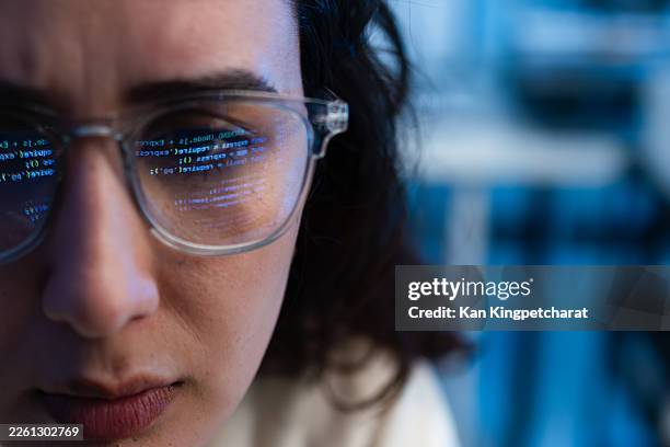 close-up of female software developer wearing glasses with programming code reflected. - hackathon stock pictures, royalty-free photos & images