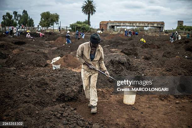 Man digs using a spade in a patch of land where artisanal miners look for gold outside Springs, Ekurhuleni, on February 15, 2026. This land, riddled...