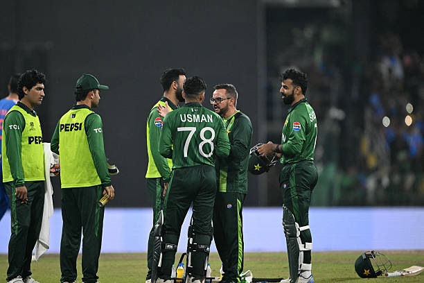 Pakistan's head coach Mike Hesson speaks with players during the 2026 ICC Men's T20 Cricket World Cup group stage match between India and Pakistan at...