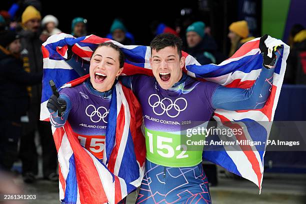 Great Britain's Matt Weston and Tabitha Stoecker celebrate winning gold after the Skeleton Mixed Team Final at the Cortina Sliding Centre, on day...