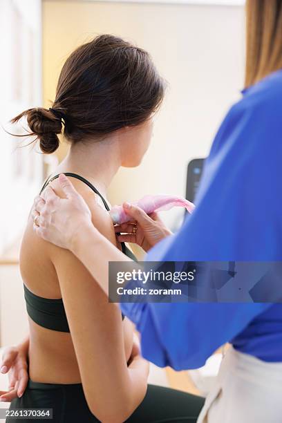 young woman in the examination in doctor's office, checking shoulder with ultrasound - inflammation stock pictures, royalty-free photos & images