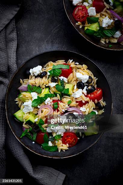 mediterranean orzo salad with feta, black olives and fresh vegetables - greek food stock pictures, royalty-free photos & images