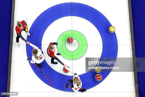 Cory Thiesse and Taylor Anderson-Heide of Team United States shake hands with Rachel Homan and Tracy Fleury of Team Canada after their Round Robin...