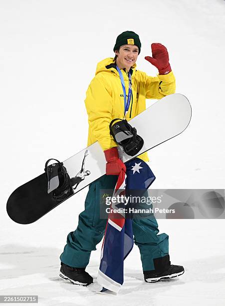 Silver medalist Scotty James of Team Australia acknowledges the fans as he holds his snowboard and a flag of Australia following the medal ceremony...