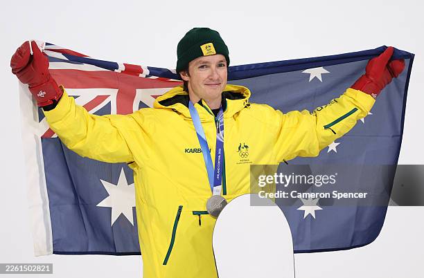 Silver medalist Scotty James of Team Australia poses for a photo whilst holding the national flag of Australia during the medal ceremony for the...
