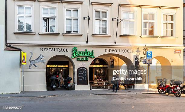 Facade of restaurant At Two Cats in rays of setting sun on Uhelny Street in Pragues Old Town in Czech Republic