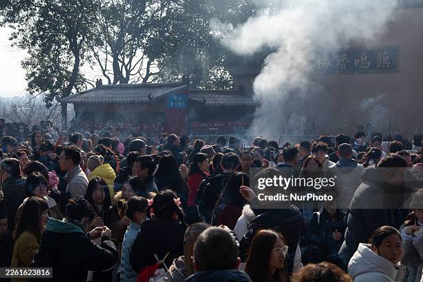 Thousands of people arrive at Jiming Temple during the first day of the Chinese Lunar New Year to burn incense to worship for blessings in Nanjing,...