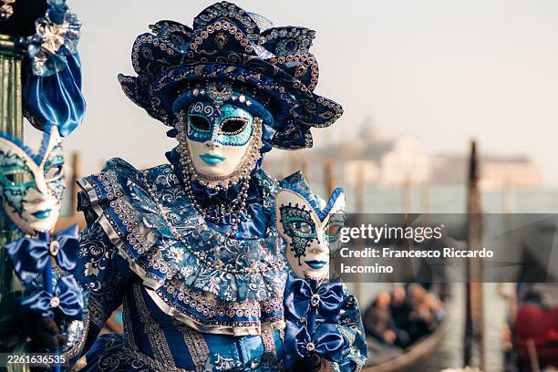 masked person in elaborate blue costume celebrates venice carnival - défilé photos et images de collection