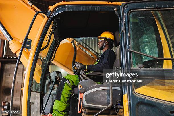 young man working on bulldozer machine at construction site - construction machinery stock pictures, royalty-free photos & images