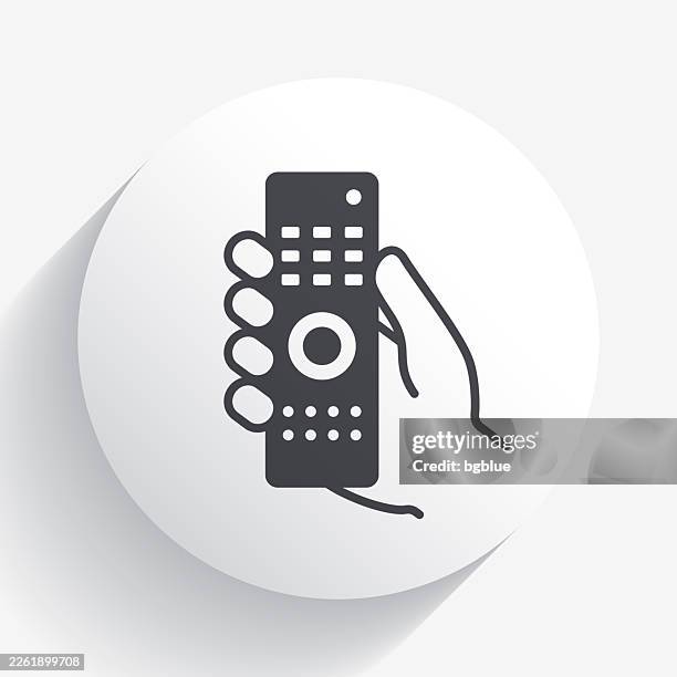 hand holding remote control. icon on circle button with long shadow - dvd remote stock illustrations