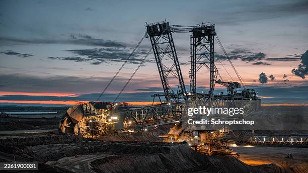 gran excavadora de rueda de cubeta trabajando en mina a cielo abierto de lignito en sunset - mina abierta fotografías e imágenes de stock