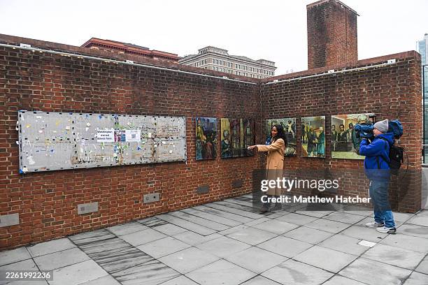 Local news crew broadcasts from in front of recently restored panels of the 'Freedom and Slavery in the Making of a New Nation' exhibit at the...