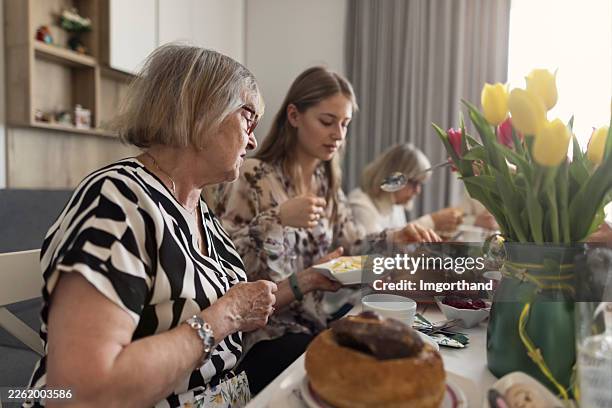 multi generation family having traditional easter rye soup in bread bowls at the decorated table. - easter breakfast stock pictures, royalty-free photos & images