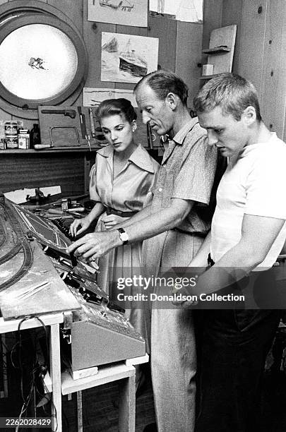 American actress Brooke Hayward and her boyfriend, American actor and filmmaker Dennis Hopper look at a toy train with an unidentified man in Los...