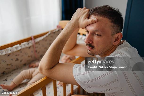 tired father with upset baby suffering with post natal depression - despair stock pictures, royalty-free photos & images