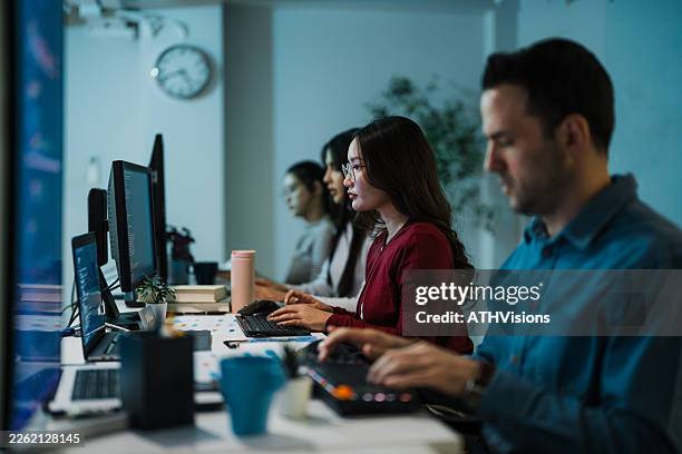 multiracial tech team collaborating on software development in modern office - api interface stock pictures, royalty-free photos & images