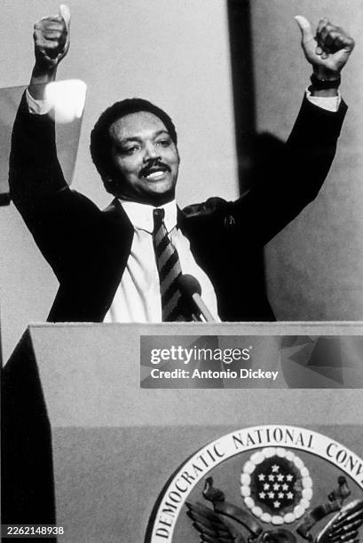 American religious & Civil Rights leader Reverend Jesse Jackson gives a 'thumbs up' gestures as he speaks from a lectern during the Democratic...