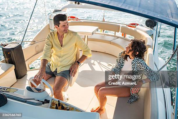 mid adult caucasian couple enjoying leisure time on private yacht in dubai - mid adult couple stock pictures, royalty-free photos & images