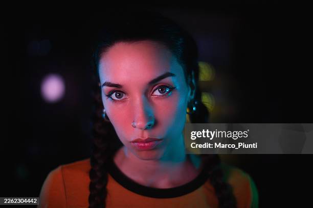 ritratto cinematografico di una giovane donna con retroilluminazione blu - adulto di mezza età foto e immagini stock
