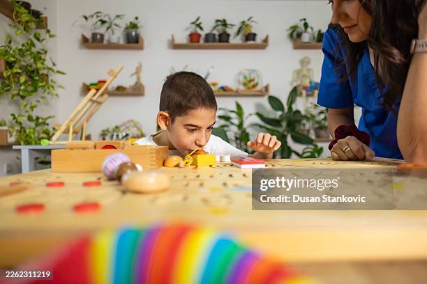 teacher and student in autism classroom with educational tools. - continuous learning stock pictures, royalty-free photos & images