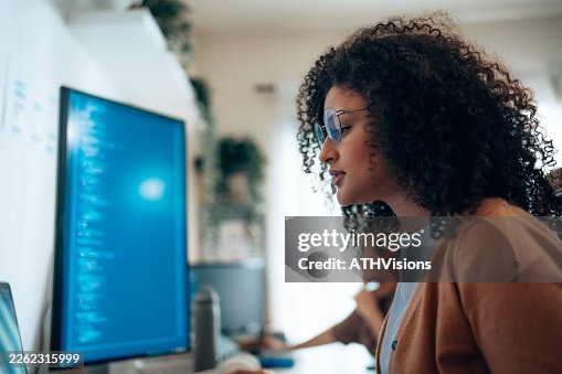 Female software engineer analyzing programming code on computer Female software engineer analyzing programming code on computer