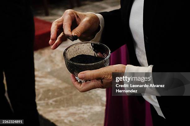 Woman grabs ashes as part of the Ash Wednesday on February 18, 2026 in Guadalajara, Mexico. Mexican Catholics mark Ash Wednesday, in Spanish:...