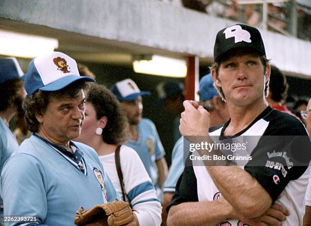 American singer, songwriter, producer, and actor, Conway Twitty, talking with an unidentified man at a celebrity baseball event in 1983 in Nashville,...