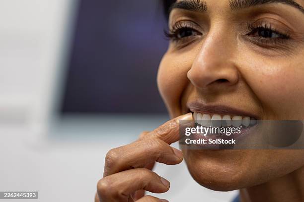 feeling her teeth after treatment - implante dentário imagens e fotografias de stock