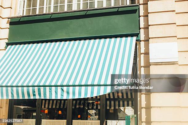 green and white striped awning on city building - awning stock pictures, royalty-free photos & images