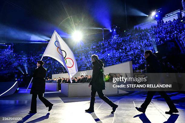 Milan mayor Giuseppe Sala and Cortina d'Ampezzo mayor Gianluca Lorenzi walk behind the Olympic flag during the flag handover ceremony at the closing...