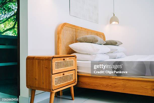 minimalist bedroom interior with wooden rattan bed nightstand - bedside table stock pictures, royalty-free photos & images