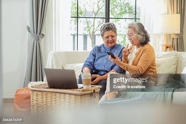una anciana jubilada asiática y sus amigos utilizan un asistente financiero de ia en casa para planificar la estrategia de pensiones, seguros y ahorros, aprendiendo tecnología de chatbot inteligente para la inversión personal, los objetivos de jubilaci� - medicare fotografías e imágenes de stock