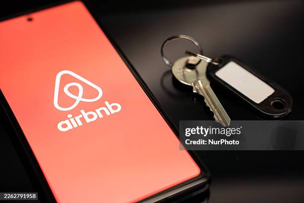 The Airbnb logo appears on a mobile phone screen next to a key in Athens, Greece, on February 24, 2026.