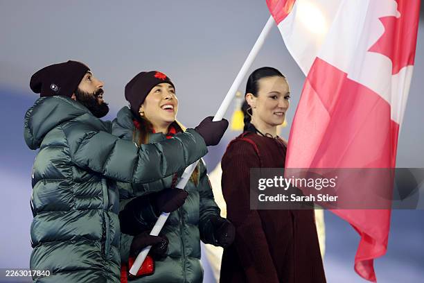 Valerie Maltais and Steven Dubois, Flagbearers of Team Canada wave the flag during the Milano Cortina 2026 Winter Olympics Closing Ceremony on day...