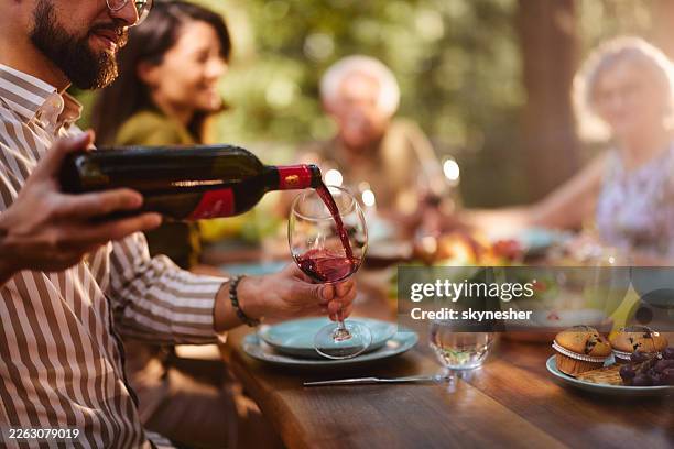 pouring red wine during family's lunch! - drinking red wine stock pictures, royalty-free photos & images