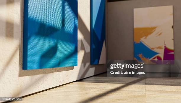 modern art paintings hanging in gallery with sunlight shadows - modern art stock pictures, royalty-free photos & images