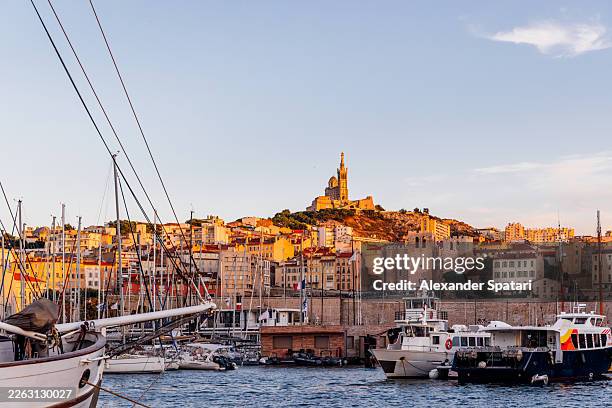 notre dame de la garde basilica and marseille skyline seen from vieux port (old port) at sunset, provence, france - golden hour stock pictures, royalty-free photos & images