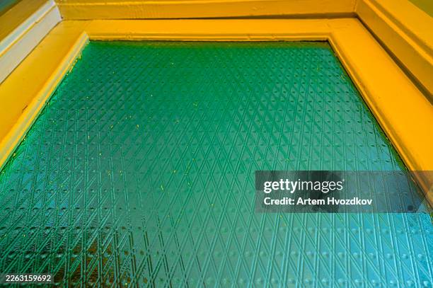 green textured glass surface framed by yellow wood - frosted glass stock pictures, royalty-free photos & images