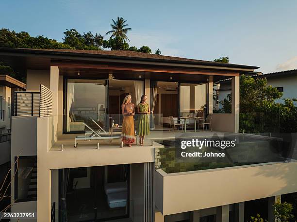 women enjoying a vacation in a luxury tropical villa - wide shot stock pictures, royalty-free photos & images