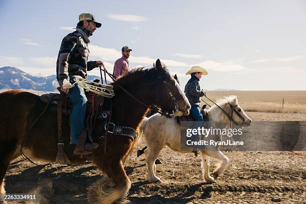 ranchers ride out to pasture to inspect cows - horseback riding stock pictures, royalty-free photos & images