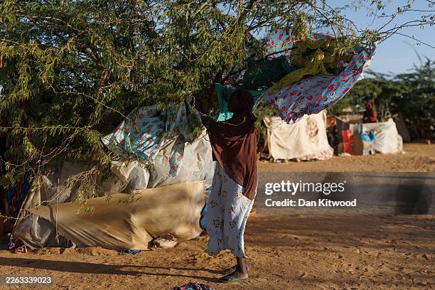Recently arrived Sudanese refugee hangs washing at her temporary shelter at the Oure Cassoni refugee camp after arriving from Sudan, on February 24,...