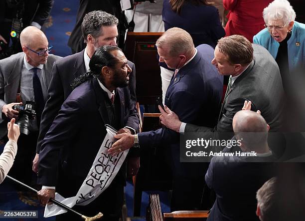 Troy Nehls grabs a sign from ejected Rep. Al Green as Trump delivers his State of the Union address during a Joint Session of Congress at the U.S....