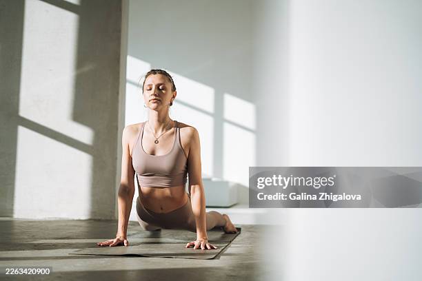 young woman in sportswear practicing upward-facing dog or urdhva mukha svanasana in yoga studio, backbend concept - yoga studio stock pictures, royalty-free photos & images