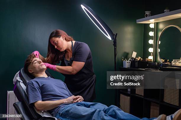 eyebrow threading at a beauty salon - threading eyebrows stock pictures, royalty-free photos & images