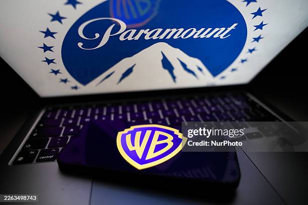 Paramount logo displayed on a laptop screen and Warner Bros logo displayed on a phone screen are seen in this illustration photo taken in Krakow,...
