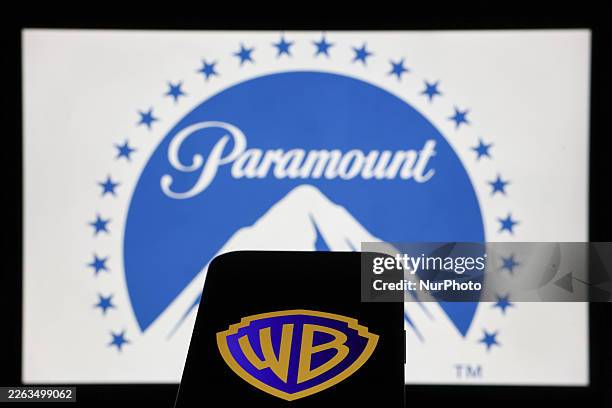 Paramount logo displayed on a laptop screen and Warner Bros logo displayed on a phone screen are seen in this illustration photo taken in Krakow,...