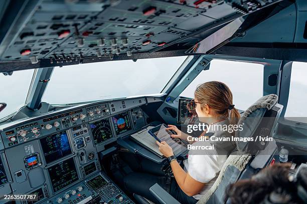 female pilot using tablet for flight operations - pilot uniform stock pictures, royalty-free photos & images
