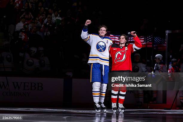 Jack Hughes of the New Jersey Devils and Tage Thompson of the Buffalo Sabres skate on the ice in a pregame welcome home ceremony following the...